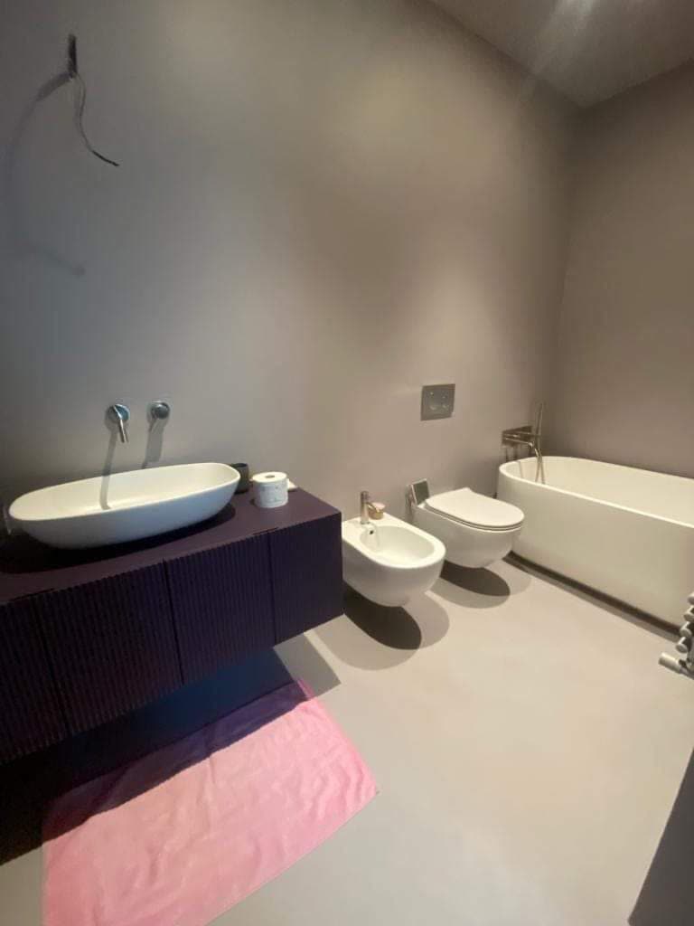 Bagno con vasca freestanding e doppio lavabo su mobile viola, Rimini